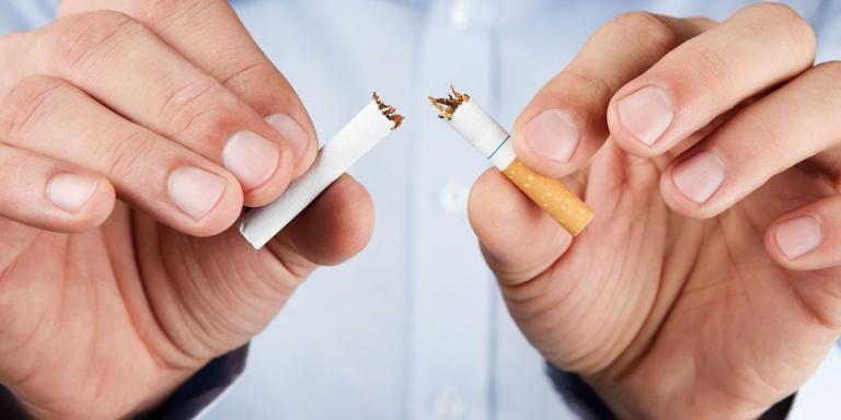 A man breaking a cigarette in half