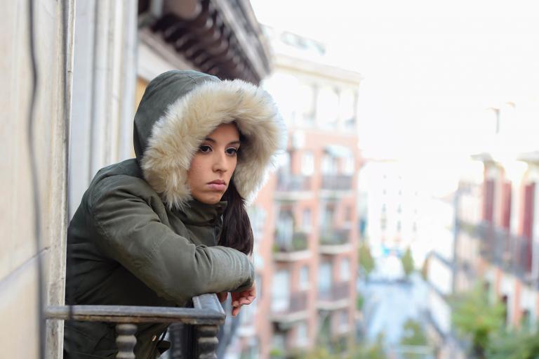 a depressed woman looking out at the city